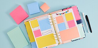 Ein offener Planer mit farbenfrohen Post-it® Notes, umgeben von Post-it® Notes in verschiedenen Größen in Pink, Blau und Pfirsichgelb

